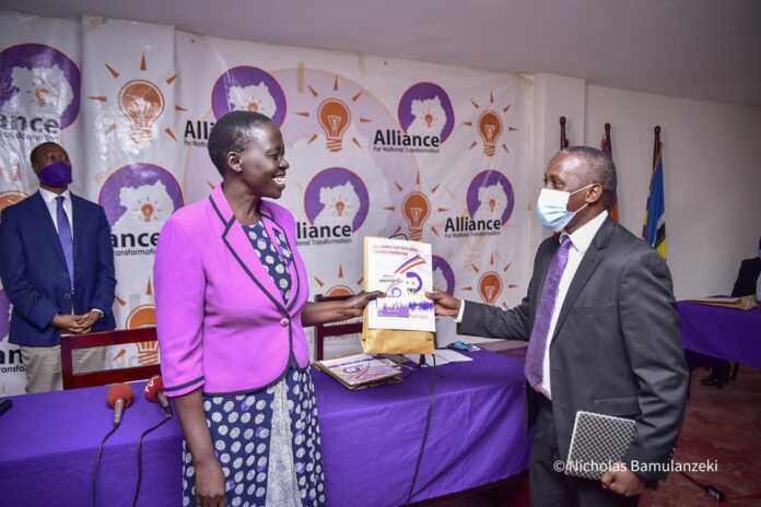 Acting ANT coordinator Alice Alaso hands over a copy of party constitution to Ntungamo Municipality MP Gerald Karuhanga.