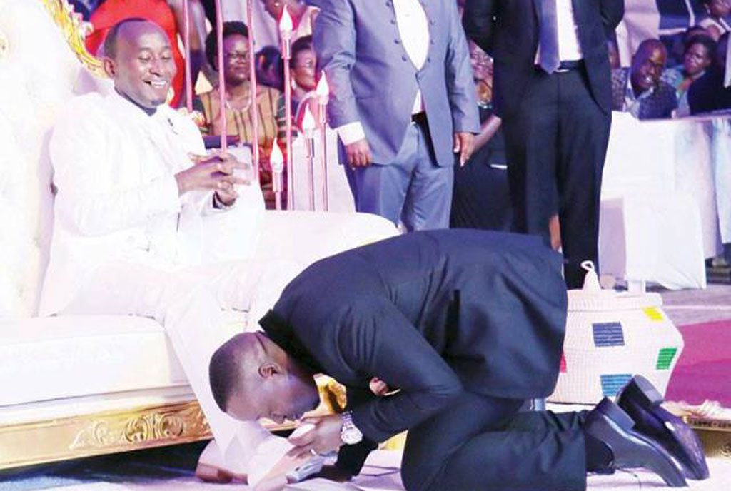 Joseph Kabuleta kisses Prophet Elvis Mbonye's shoes. Kabuleta has declared his 2021 presidential bid. 